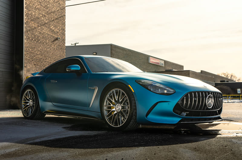 Blue Mercedes-AMG GT coupe in front of a brick building