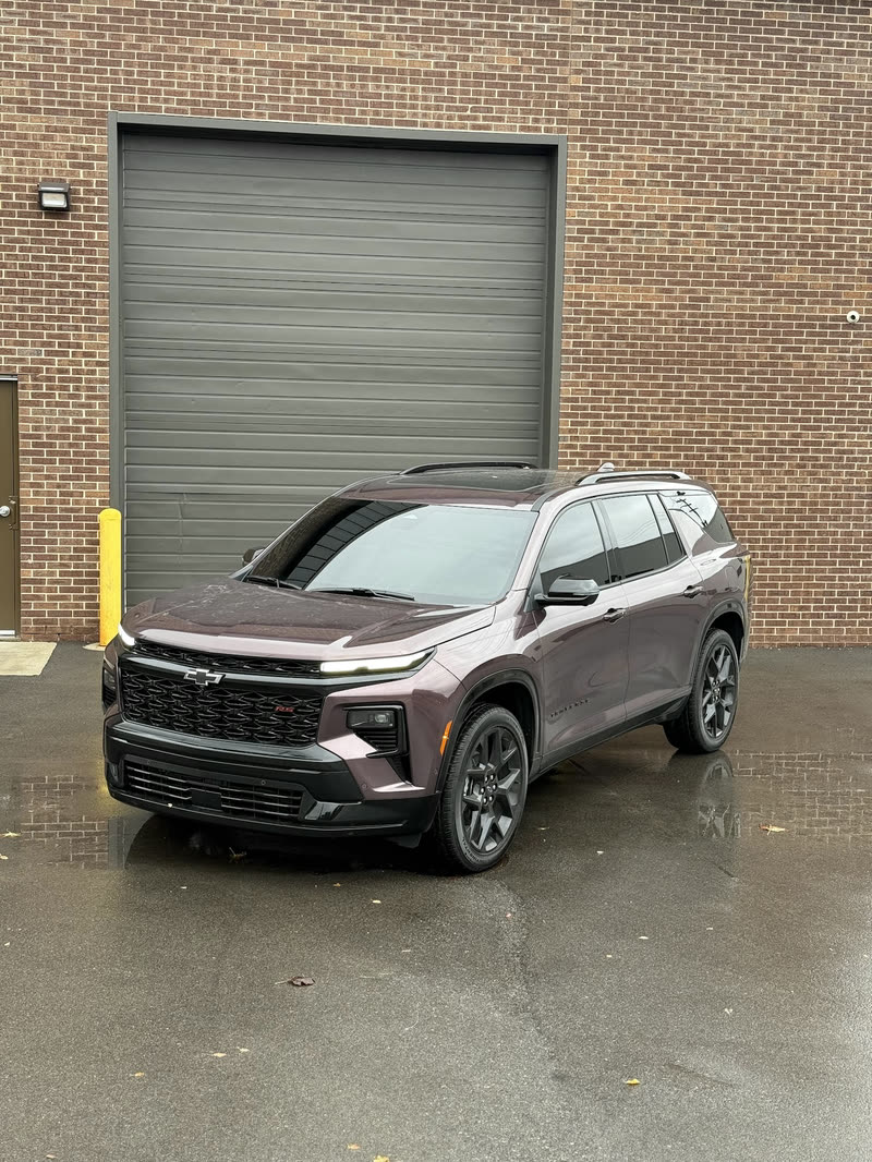 Grey Chevrolet SUV parked in front of a brick garage door