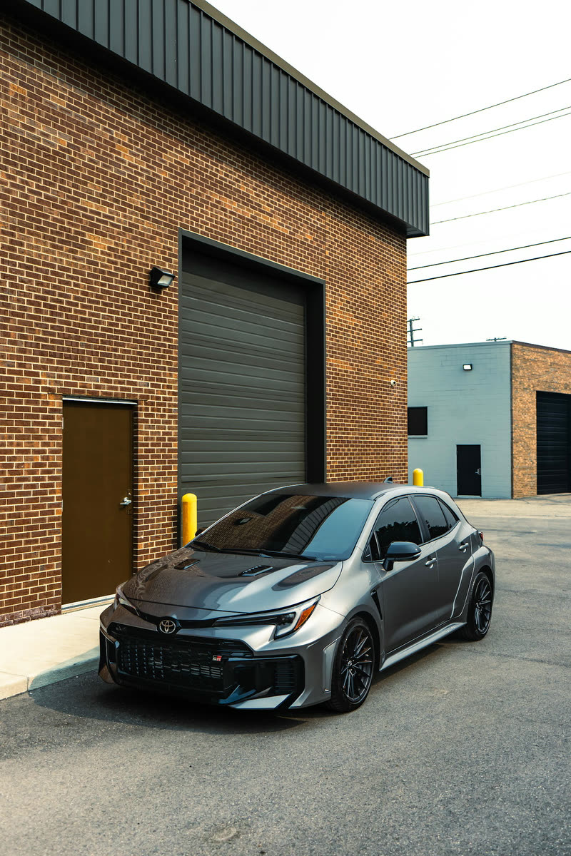 Grey Toyota GR Corolla in front of a brick building
