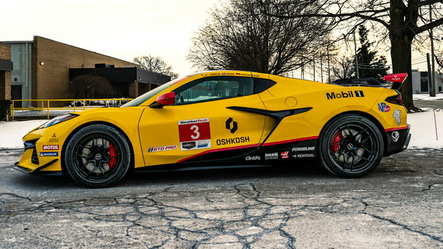 Side view of a yellow Corvette Z06 with race livery parked in front of a brick building, for the tint shade preview